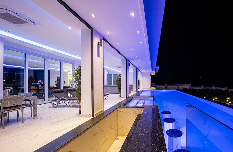 Night time picture of a beautiful villa terrace and infinity pool with bar. Photo by Sean Witt RE/MAX Capital Property Real Estate Consultant.
